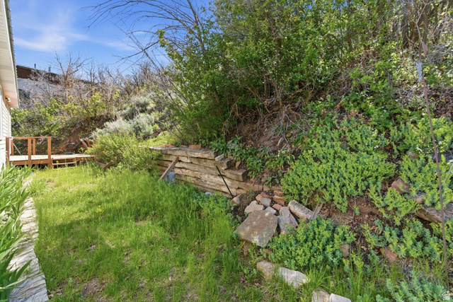 380 Luzern Road Midway, UT 84049 - Photo 59 of 74 Tiered landscaping with a wooden retaining wall, a multi-level deck, and a grass area
