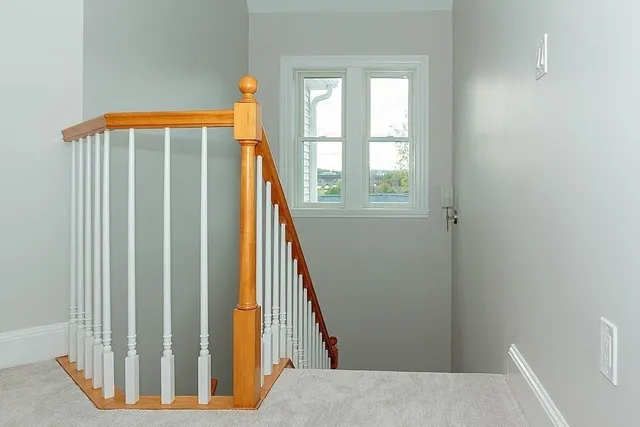 a view of staircase with white walls and a window