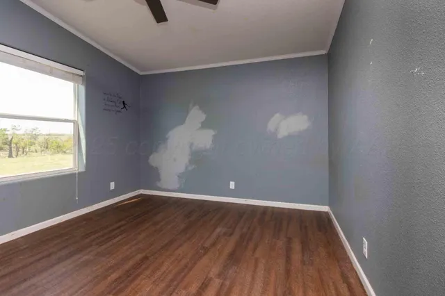 an empty room with windows and fireplace