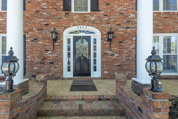 a view of a house with a small yard and wooden fence