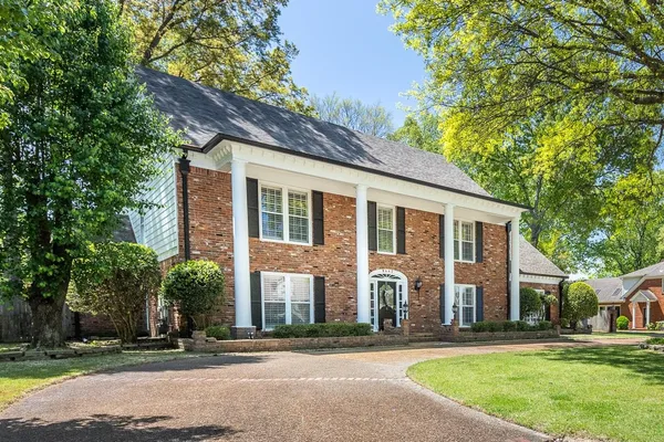 a front view of a house with a yard and pathway