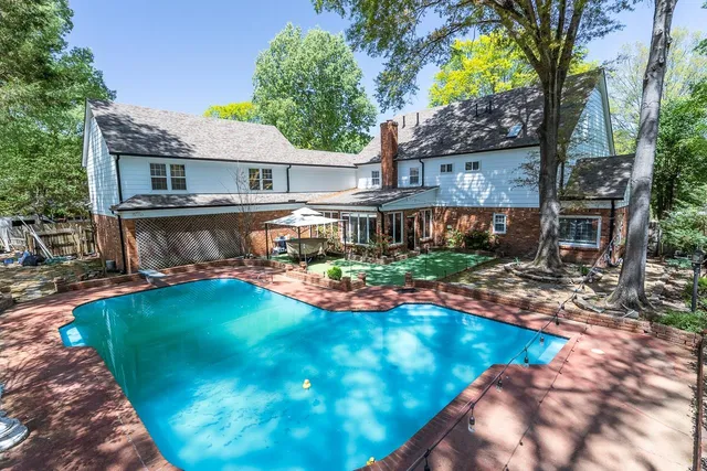 a view of a house with a yard patio and swimming pool