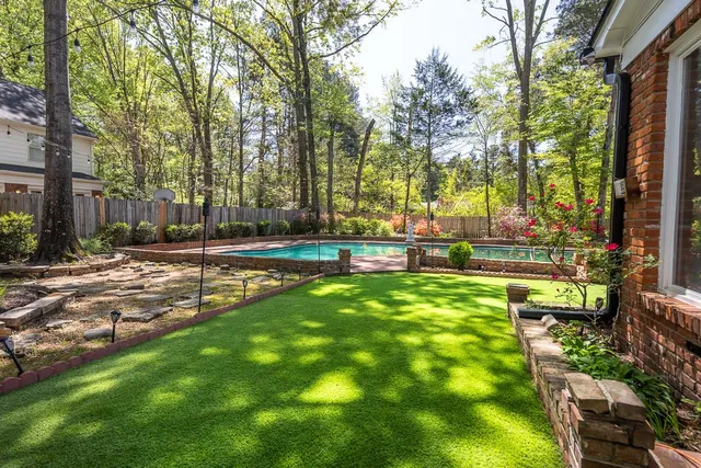a swimming pool with outdoor seating and yard