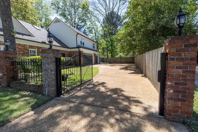 a view of a house with a small yard and wooden fence