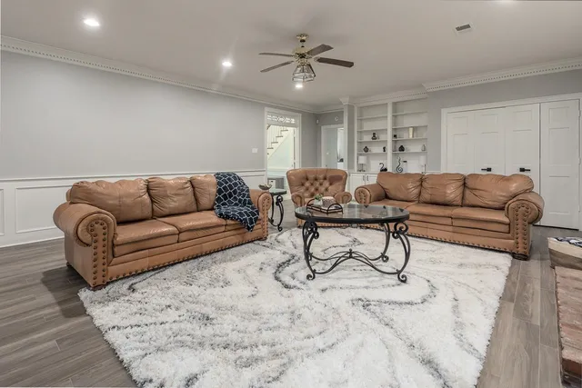 a living room with furniture and a ceiling fan