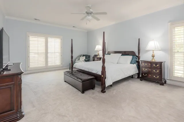 a spacious bedroom with a bed a chandelier and a couch