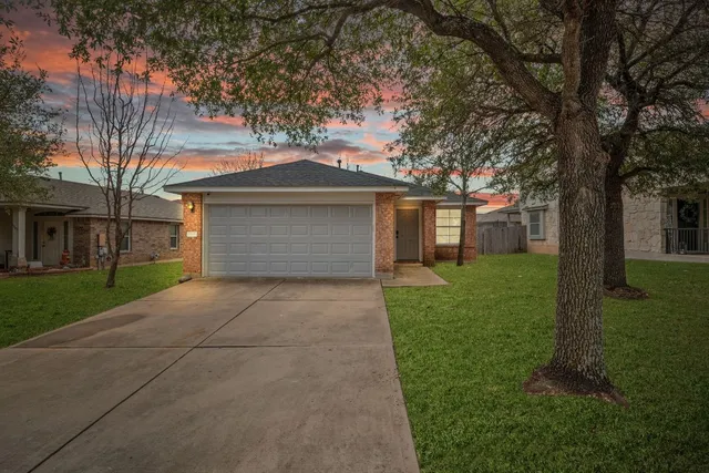 a front view of a house with a yard and trees
