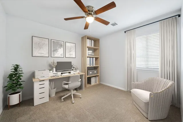 a view of a workspace with furniture and a window