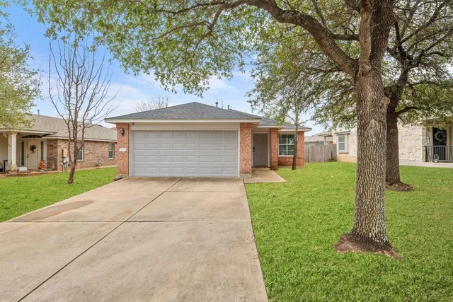 a front view of a house with a yard and trees