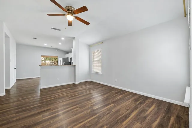 a view of a kitchen with wooden floor and a ceiling fan