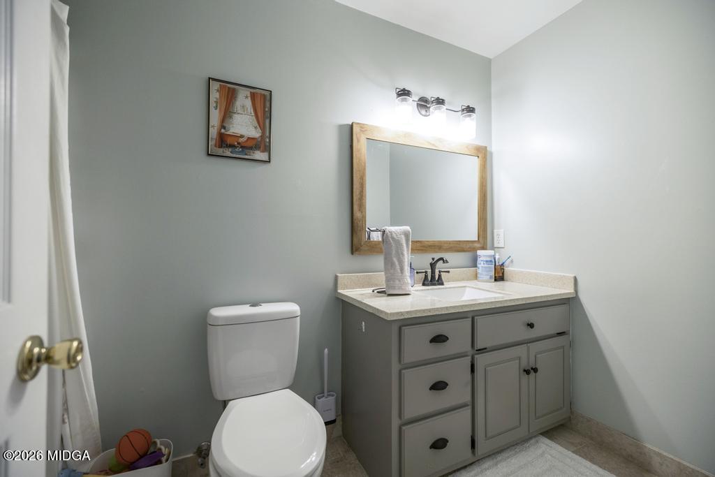 128 Springwood Court Macon, GA 31210 - Photo 14 of 21 a bathroom with a toilet a sink and mirror