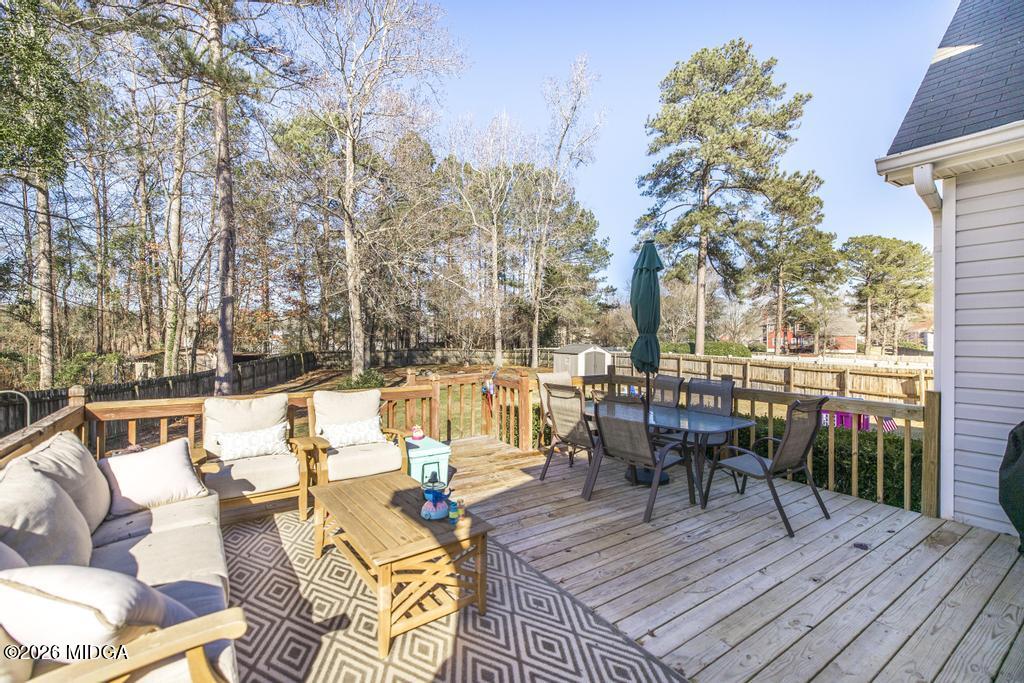 128 Springwood Court Macon, GA 31210 - Photo 19 of 21 a view of a patio with couches table and chairs and wooden floor