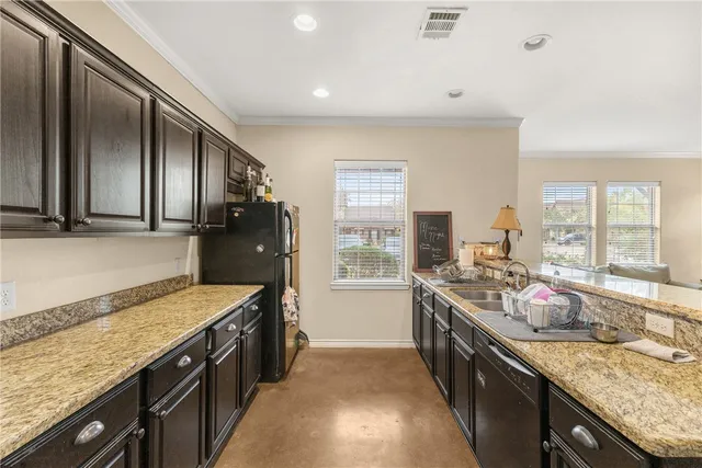 a kitchen with granite countertop stainless steel appliances a sink stove top oven and cabinets