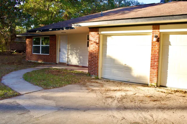 a view of a house with a small yard and garage