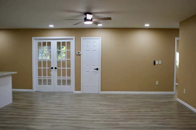 an empty room with wooden floor and windows