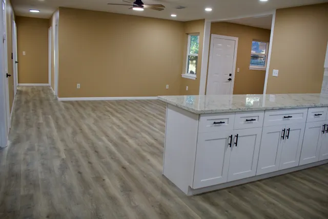 a spacious bathroom with a granite countertop sink and a mirror