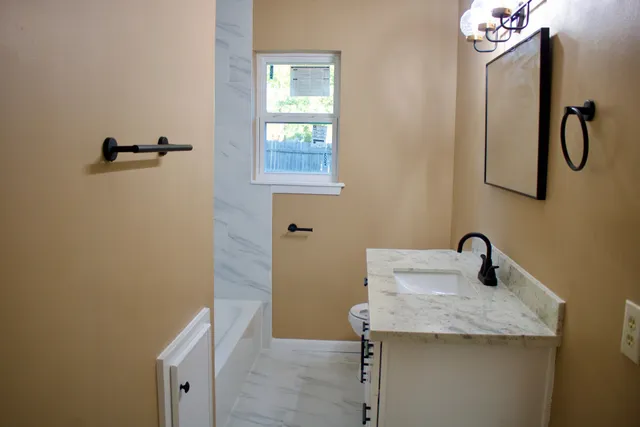a bathroom with a granite countertop sink and a mirror