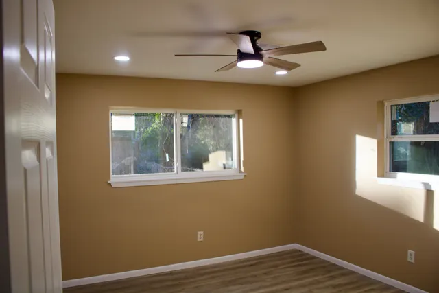 a view of empty room with window and wooden floor