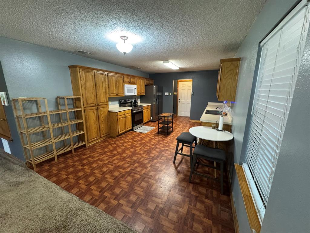 705 East James Street Wills Point, TX 75169 - Photo 12 of 26 a living room with furniture a flat screen tv and kitchen view