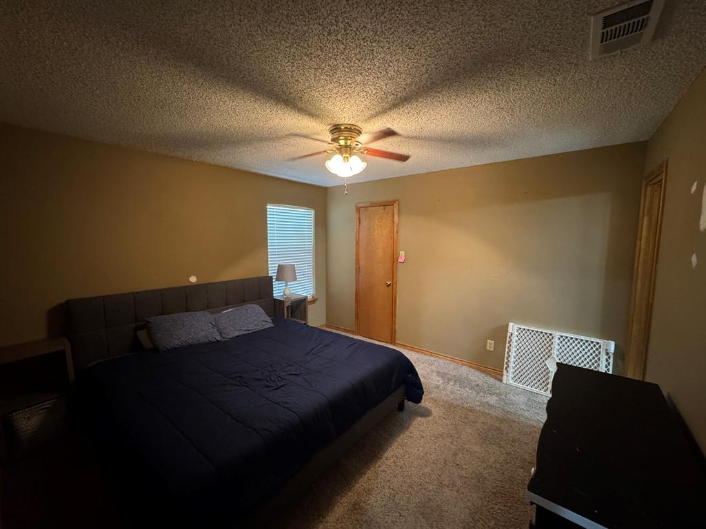 705 East James Street Wills Point, TX 75169 - Photo 14 of 26 a bedroom with a bed and a ceiling fan