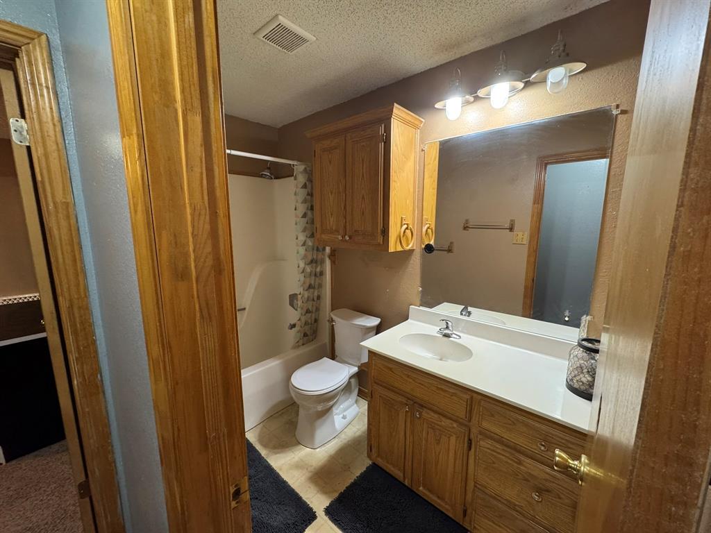 705 East James Street Wills Point, TX 75169 - Photo 15 of 26 a bathroom with a sink and mirror with toilet