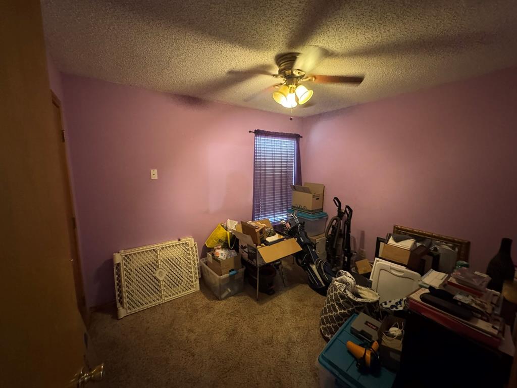 705 East James Street Wills Point, TX 75169 - Photo 16 of 26 a bedroom with bed and a chandelier