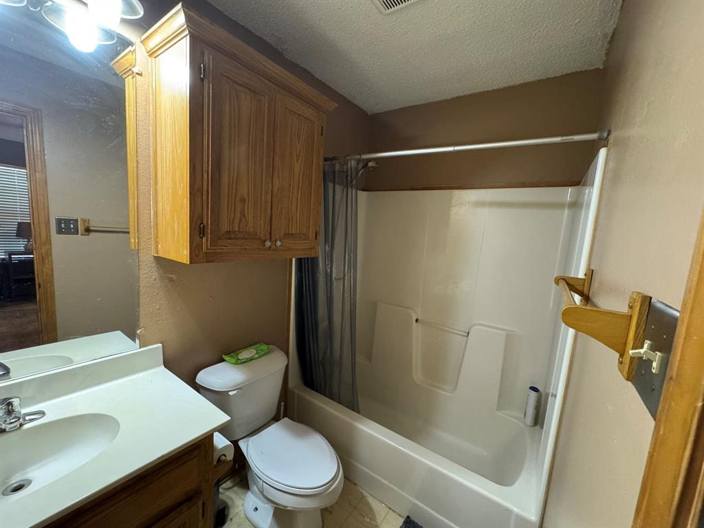 705 East James Street Wills Point, TX 75169 - Photo 19 of 26 a white toilet sitting next to a bathroom sink