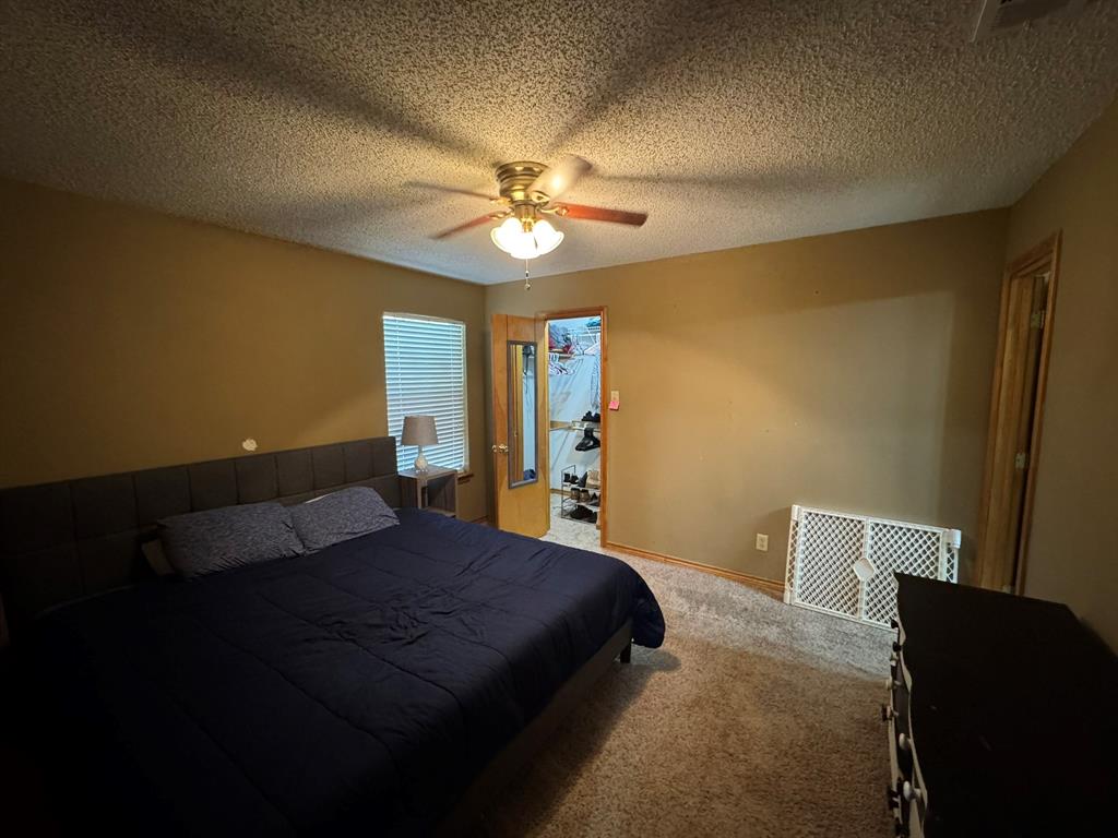 705 East James Street Wills Point, TX 75169 - Photo 20 of 26 a bedroom with a bed and a chandelier