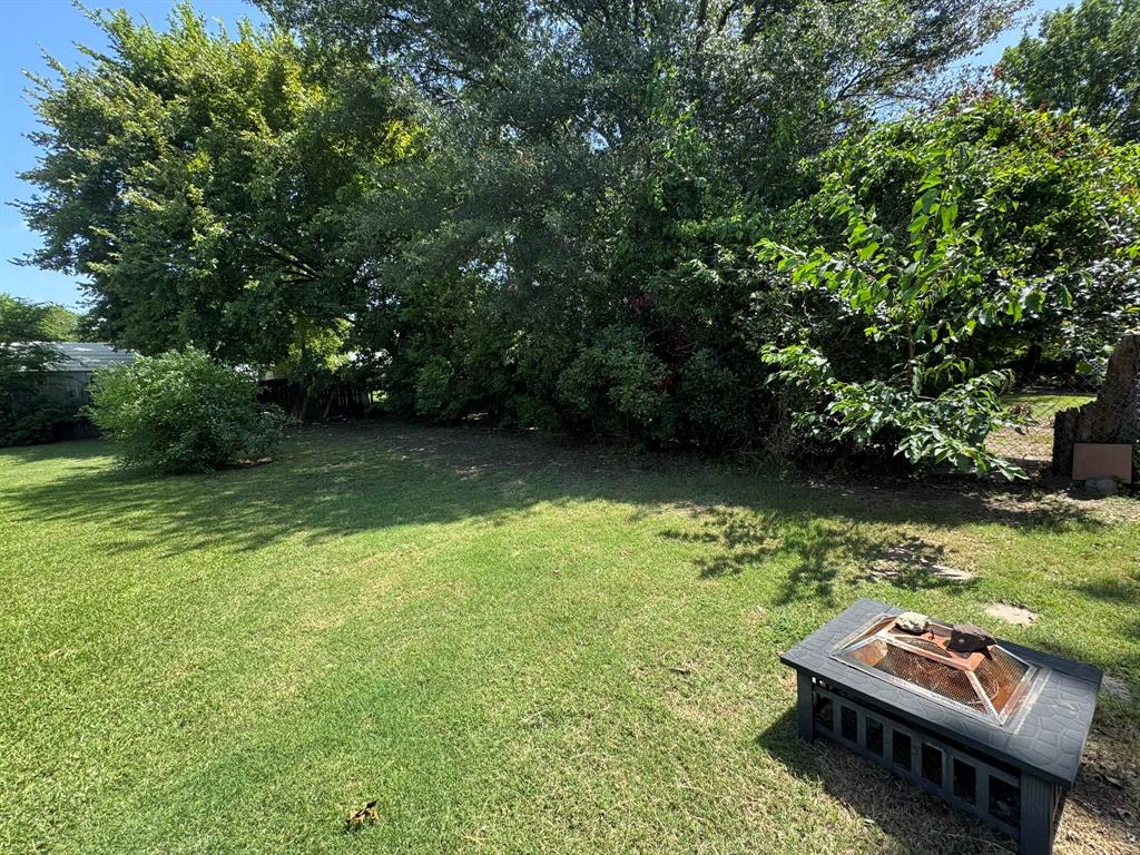 705 East James Street Wills Point, TX 75169 - Photo 7 of 26 a view of a yard with lawn chairs and a large tree