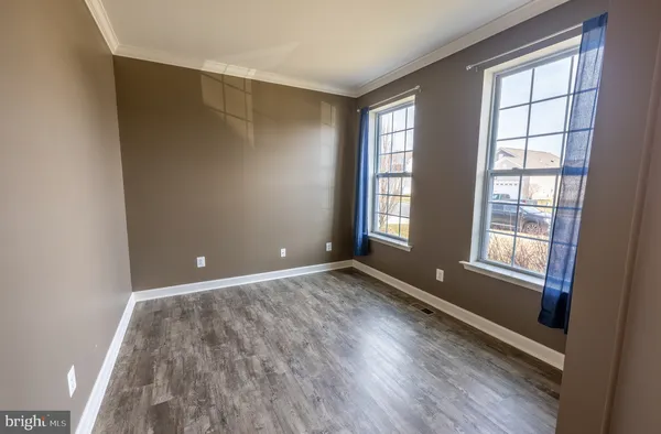 an empty room with wooden floor and a fireplace