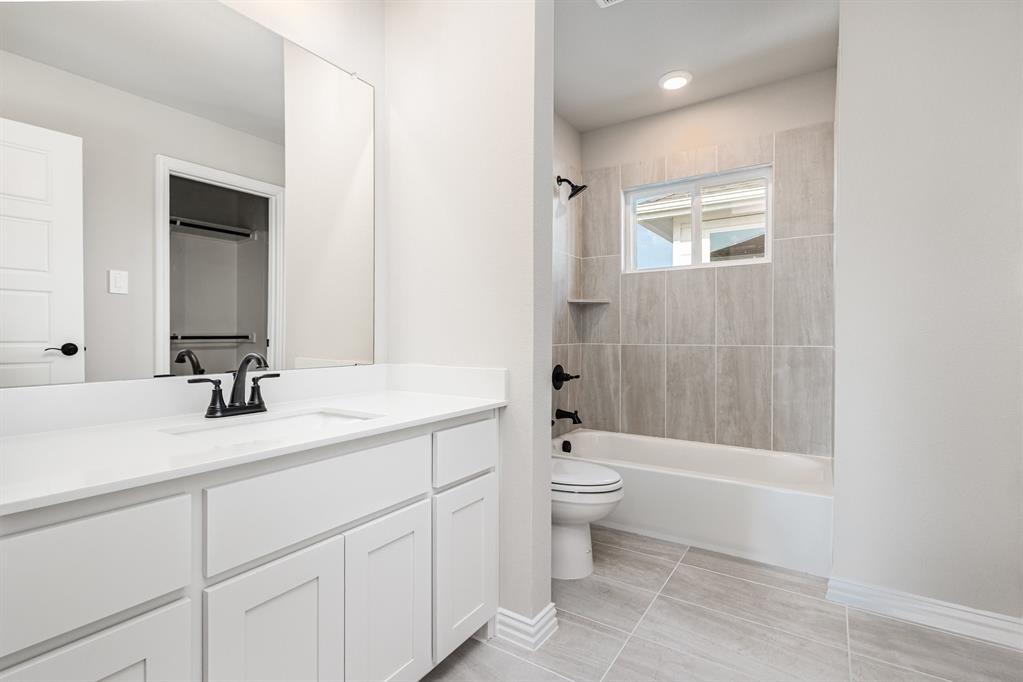 7221 Bayhill Drive Rowlett, TX 75088 - Photo 17 of 18 Bathroom featuring shower / bath combination, vanity, and light tile patterned floors