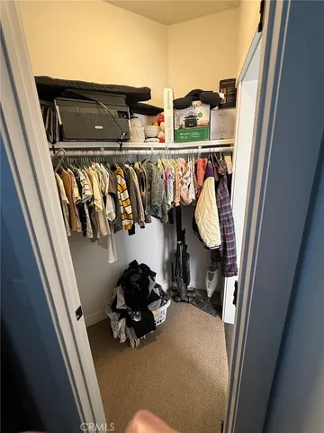 a view of walk in closet with clothes and shoes