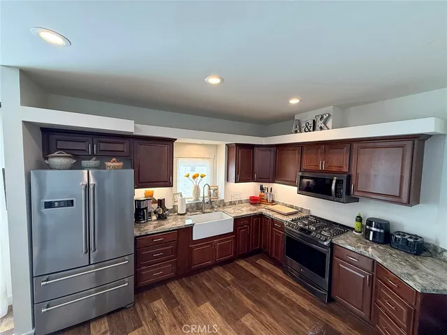 a kitchen with granite countertop stainless steel appliances and wooden cabinets