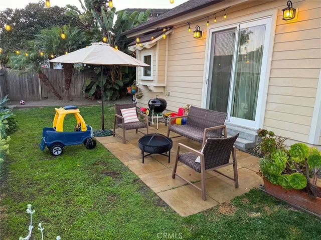a view of backyard with table and chairs under an umbrella