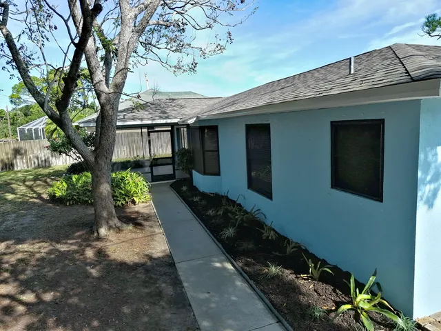 a view of a house with a tree in front of it