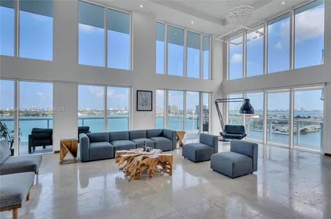 a living room with furniture and a view of kitchen