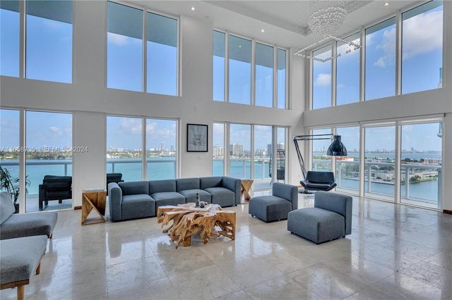 a living room with furniture and a view of kitchen