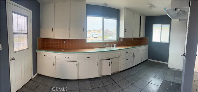 a kitchen with a sink window and cabinets