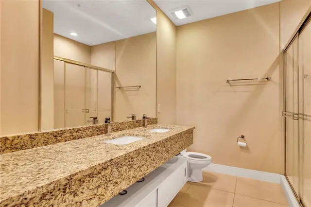 a bathroom with a granite countertop sink a toilet and shower