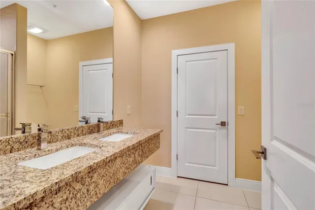 a spacious bathroom with a granite countertop sink and a mirror