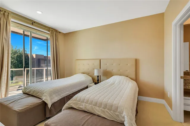 a bedroom with two beds and a large window