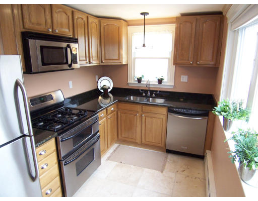 67 Green Street, Unit B Marblehead, MA 01945 - Photo 1 of 11 a kitchen with stainless steel appliances granite countertop a stove a microwave a sink and cabinets