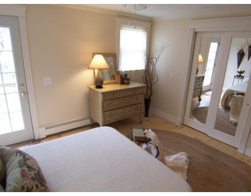 67 Green Street, Unit B Marblehead, MA 01945 - Photo 3 of 11 a bedroom with a bed and a mirror