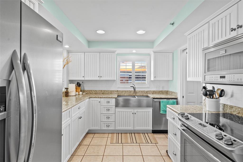13650 Gulf Boulevard, Unit 604 Madeira Beach, FL 33708 - Photo 26 of 71 a kitchen with stainless steel appliances granite countertop a sink stove and refrigerator