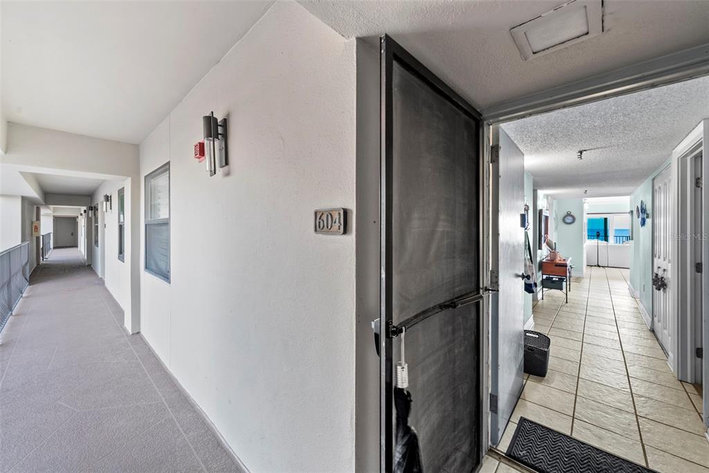 13650 Gulf Boulevard, Unit 604 Madeira Beach, FL 33708 - Photo 10 of 71 a hallway with a dining table and chairs
