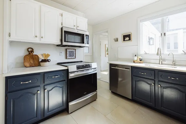 a kitchen with stainless steel appliances granite countertop a sink stove oven and white cabinets
