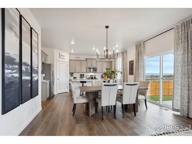 a view of a dining room and livingroom with furniture wooden floor a chandelier