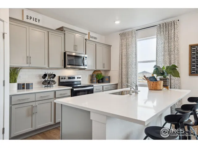 a kitchen with stainless steel appliances granite countertop a sink a stove and cabinets
