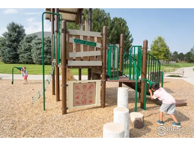 a view of a building with floor to ceiling windows and wooden fence