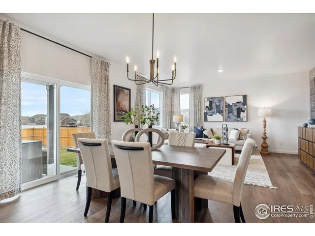 a view of a dining room with furniture a chandelier and wooden floor